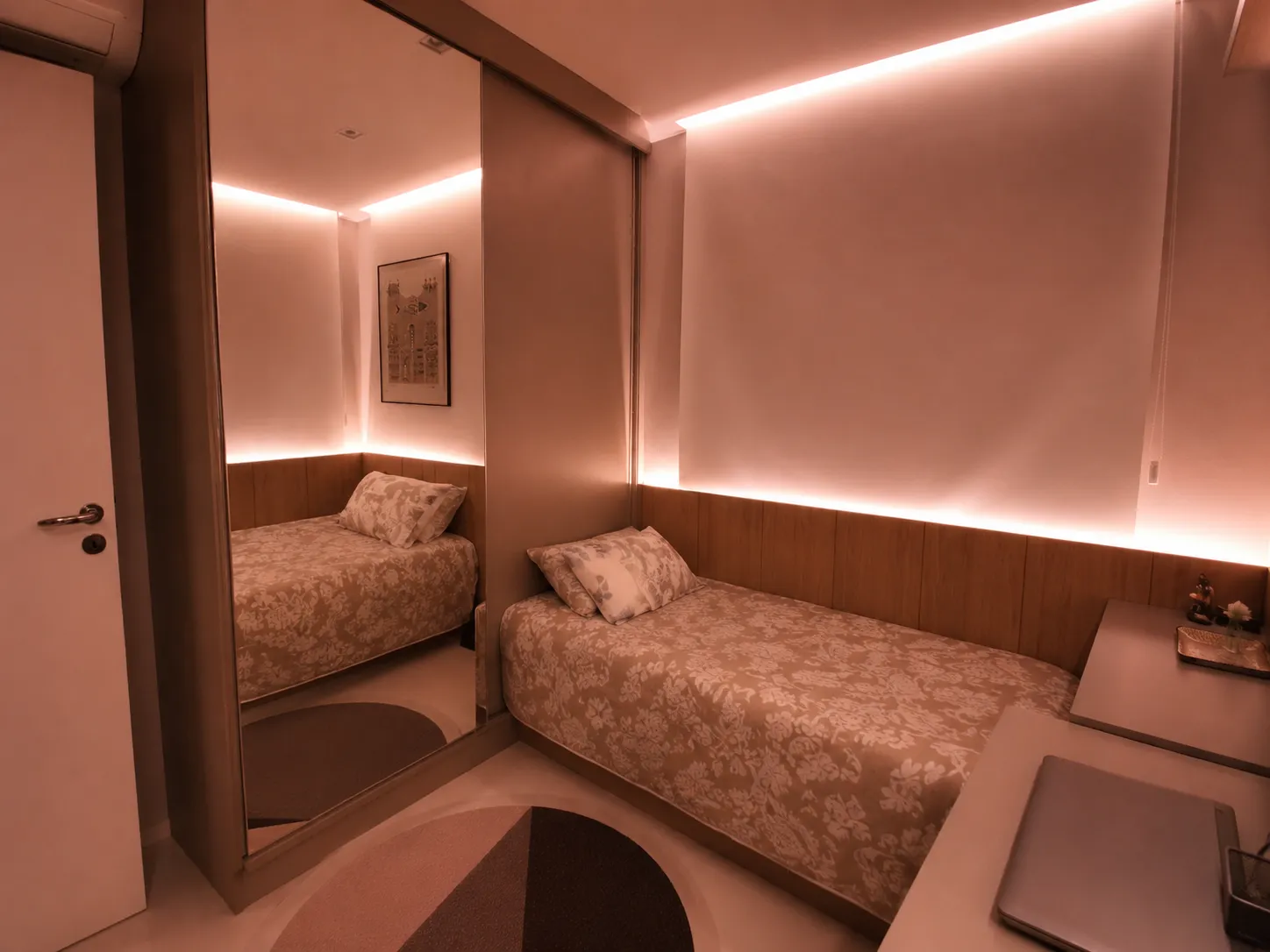 Ambiente mobiliado pela Seventh Day — cama, painel de madeira e iluminação embutida